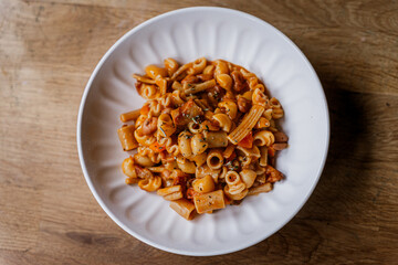 Pasta Fagioli soup in a white bowl with fresh rosemary, traditional italian comfort food