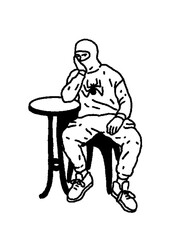 Edgy urban man in balaclava and spider hoodie sitting lonely