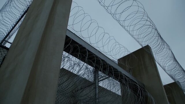 Barbed wire fencing with concrete structures against a cloudy sky Stock Video