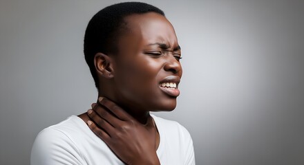 Black woman experiencing throat pain while holding her neck  
