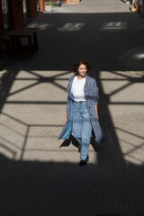 middle aged woman walks on the street of the  city. copy space. Slow life. Enjoying the little things. spends time in nature in summer