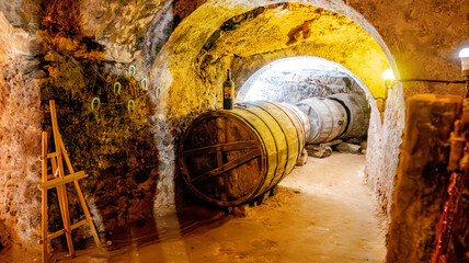 Vintage wine barrels resting in rustic stone cellar