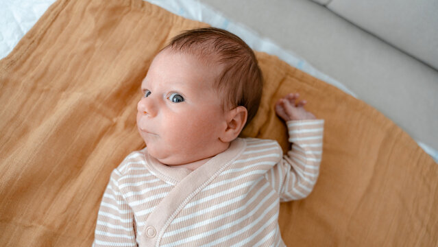 Newborn baby lying on soft blanket in cozy home setting