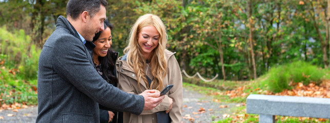 Portrait of diverse business colleagues stand outdoors in a park, smiling and laughing together...