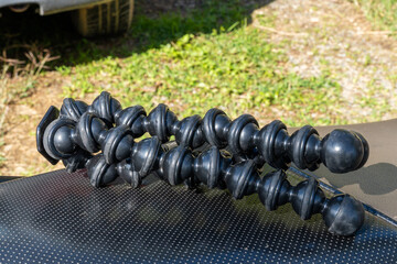 Flexible GorillaPod tripod with segmented legs placed on dirt and grass.