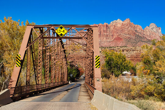 Historic Steel One Lane Parker through Truss Style Bridge over the Virgin River in Rockville Utah with a View of Mount Kinesava in Autumn.