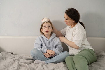 Mother and daughter bonding with pet mouse at home