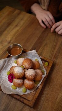 Ponchiki are soft, golden fried donuts, often dusted with powdered sugar and enjoyed as a sweet treat.
