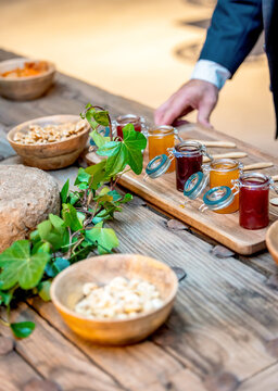 Jars of jams and nuts on rustic wooden table