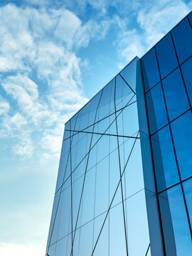 Modern glass building reflecting a blue sky