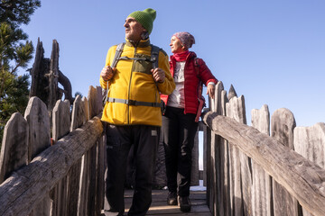 Couple hiking along a rustic wooden fence in autumn