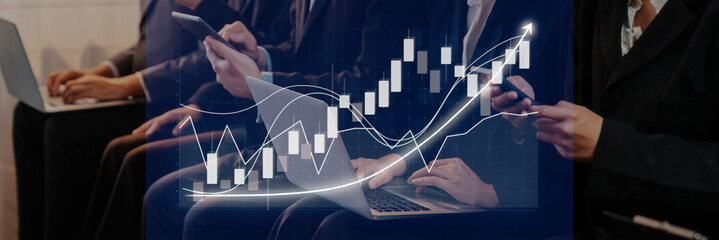 Business professionals engaged in financial analysis using devices while examining growth trends on a graphical chart in a collaborative office setting. Axiom