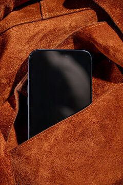 Smartphone tucked inside a stylish brown fabric pocket