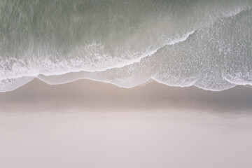 Close-Up Aerial View of Ocean Waves Reaching Sandy Beach