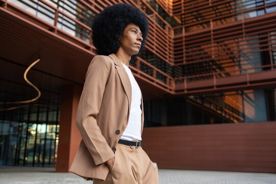 Person wearing a brown blazer in urban setting