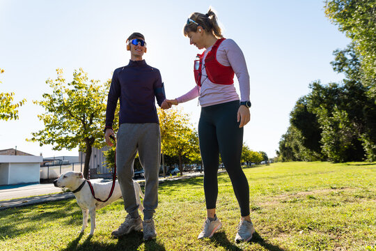 Outdoor fitness with a couple and dog in sunny park