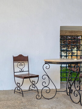 Wrought iron table and chair with ornate designs