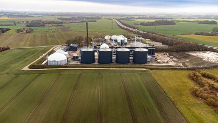 Aerial drone photo of a biogas plant surrounded by Danish countryside, highlighting renewable energy infrastructure and rural landscape.