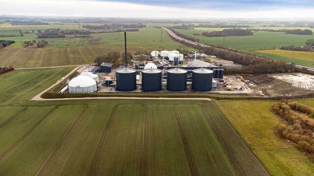 Industrial biogas digester tanks and renewable energy infrastructure at a Danish bioenergy plant, aerial perspective