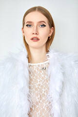 Portrait of a woman in a white transparent shirt with long blonde hair, depicted in close-up.