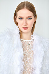 Portrait of a woman in a white transparent shirt with long blonde hair, depicted in close-up.