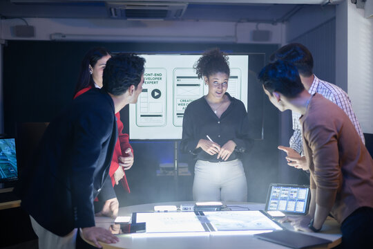 Diverse team of developers collaborating reviewing UX UI design project and discussing digital marketing and web development at meeting. creative AI solution project. Application and program design - Powered by Adobe