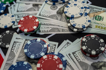 Casino poker chips on US hundred dollar bills representing gambling, luck, risk and financial winnings