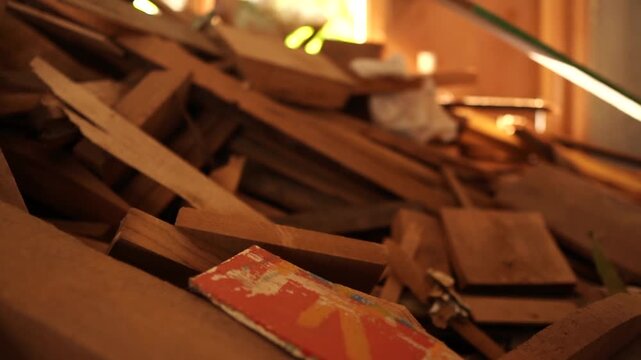 A close-up of scattered wooden offcuts in a furniture workshop, showing a chaotic pile of scrap wood, timber planks, debris, firewood pieces and leftover materials used for carpentry, DIY and salvage.