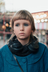 Fototapeta premium Sad teen girl at outdoor Christmas market in a snow-free city