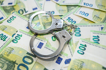 Euro bills and handcuffs concept of bribery and illegal money