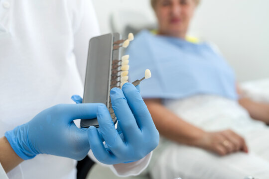 dentist with pensioner choose teeth shade with samples for bleaching treatment, dentistry healthcare concept