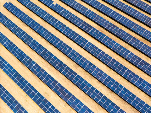 Photovoltaic arrays across vineyard rows in the Italian countryside, aerial drone view. Renewable electricity for low-carbon power and grid decarbonization