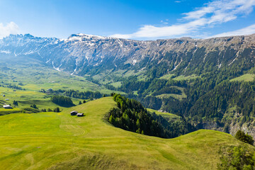 Obraz premium Wide meadow plateau of Alpe di Siusi with mountain ridge, aerial view. Dolomites landscape in summer daylight