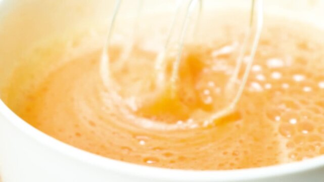 Blurred culinary background, slow motion of beating eggs with sugar, making dough.