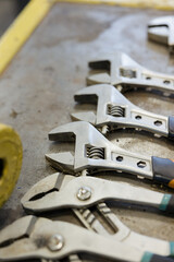 Various adjustable wrenches neatly arranged on a workbench in a busy workshop