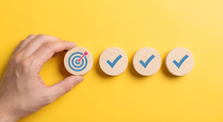 Hand Placing Wooden Token with Target Icon Next to Success Checkmarks on Bright Yellow Background
