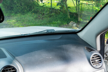 View from passenger seat showing dashboard and windshield in rural setting.