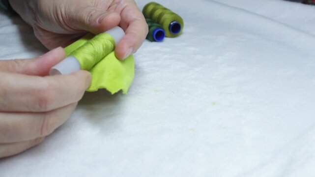 Checking thread color compatibility with fabric close-up  with copyspace at bottom