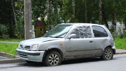 An old gray broken car parked on the street, Bolshevik Avenue, Saint Petersburg, Russia, August 31, 2025