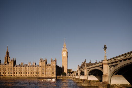 The houses of parliament with Big Ben, Elizabeth Tower and Westminster bridge at sunset.