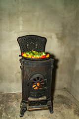 Grilled meat and mixed vegetables cooking in cast iron pan on wood burning stove. Indoor food preparation photography. Home cooking and rustic kitchen concept. Design for poster, banner, wallpaper, pr