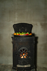Grilled meat and mixed vegetables cooking in cast iron pan on wood burning stove. Indoor food preparation photography. Home cooking and rustic kitchen concept. Design for poster, banner, wallpaper, pr
