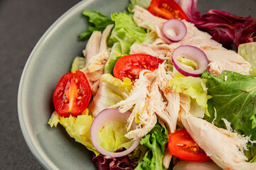 Salad chicken meat and vegetables tomato, green leaf lettuce, onion natural product tasty snack fresh delicious gourmet food background on the table rustic top view copy space keto and paleo diet