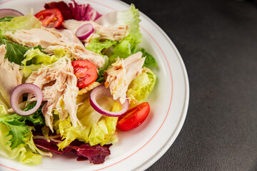 Salad chicken meat and vegetables tomato, green leaf lettuce, onion natural product tasty snack fresh delicious gourmet food background on the table rustic top view copy space keto and paleo diet