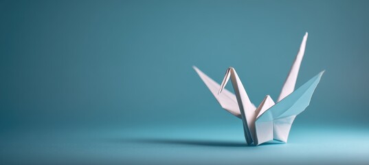 Naklejka premium Origami crane from recycled paper on aqua gradient background with copy space layout