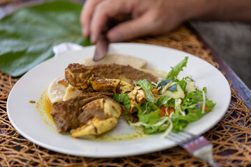 Traditional Tobago Crab and Dumpling Served on White Plate with Fresh Salad