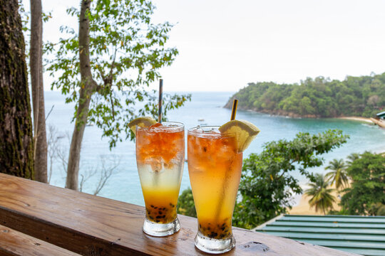 Tropical cocktails overlooking Castara Bay with ocean and lush hillside view in Tobago