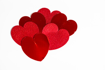 Red glitter and foil heart shapes on a white background, symbolizing love and romance. Perfect for Valentines Day and wedding celebration.