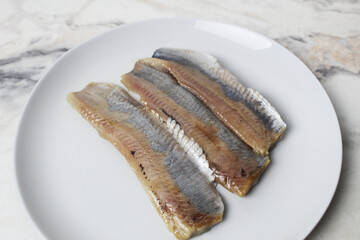 Pieces of herring fillet on a plate View from above. Preparation of fish dishes. horizontal photo