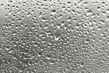 Drops on glass in sunset light. Perfect backdrop for your design. Selective focus. Demonstrating color of 2026 year, Cloud Dancer